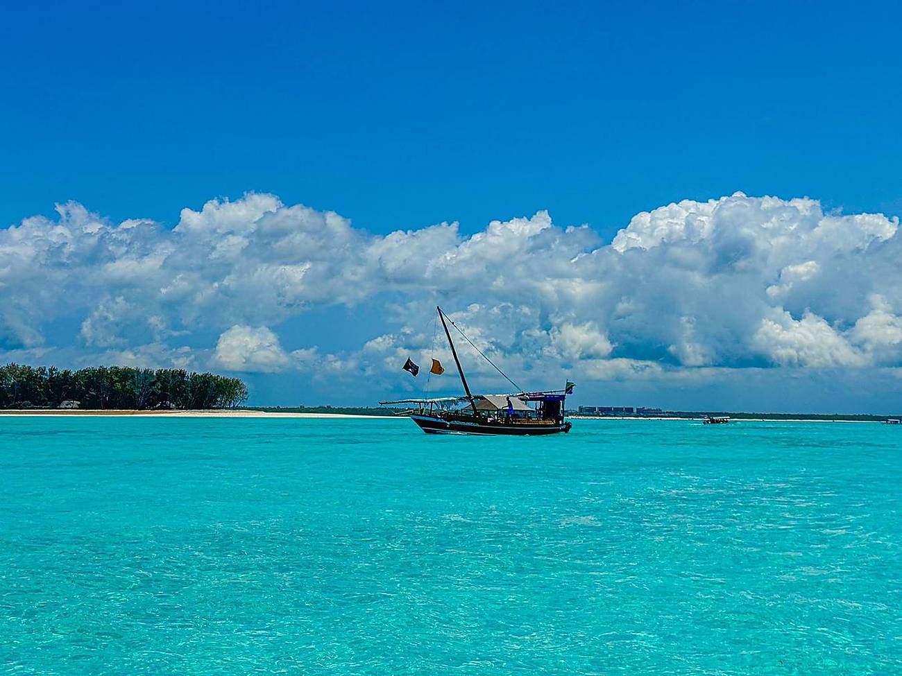 Aerial view of the turquoise Zanzibar coast with a dhow